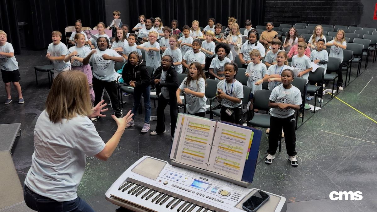   Music Teacher leads her choir club through a song